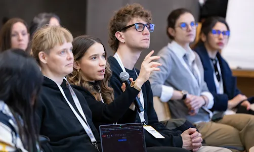 One woman in the audience is directing a question to the event's host.