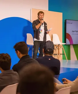A person is addressing a large event audience with a mic.
